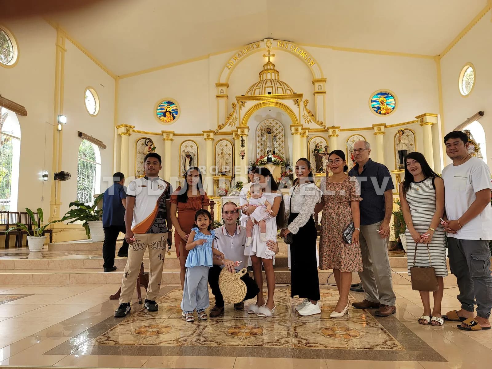 a group of people posing for a photo inside a church with ornate decorations