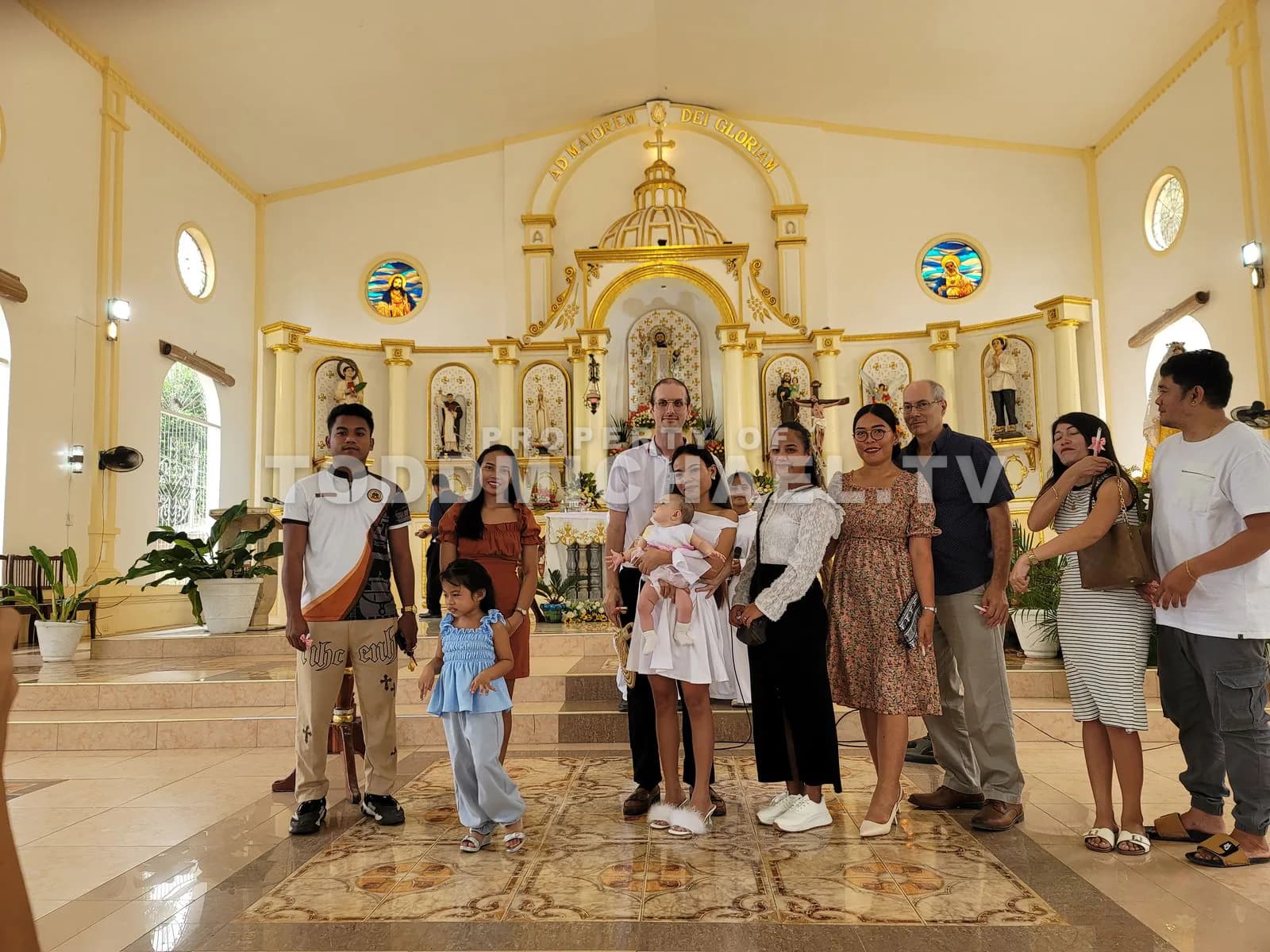 A group photo taken indoors in front of an ornate church interior, capturing a family moment.