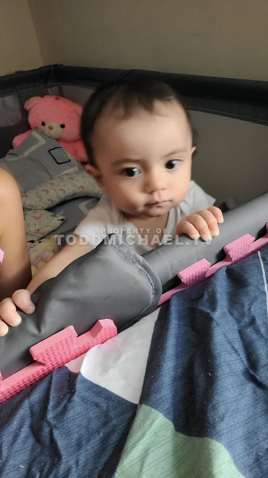 a baby lying in a crib with toys around, captured on June 13th at 11:23 AM.