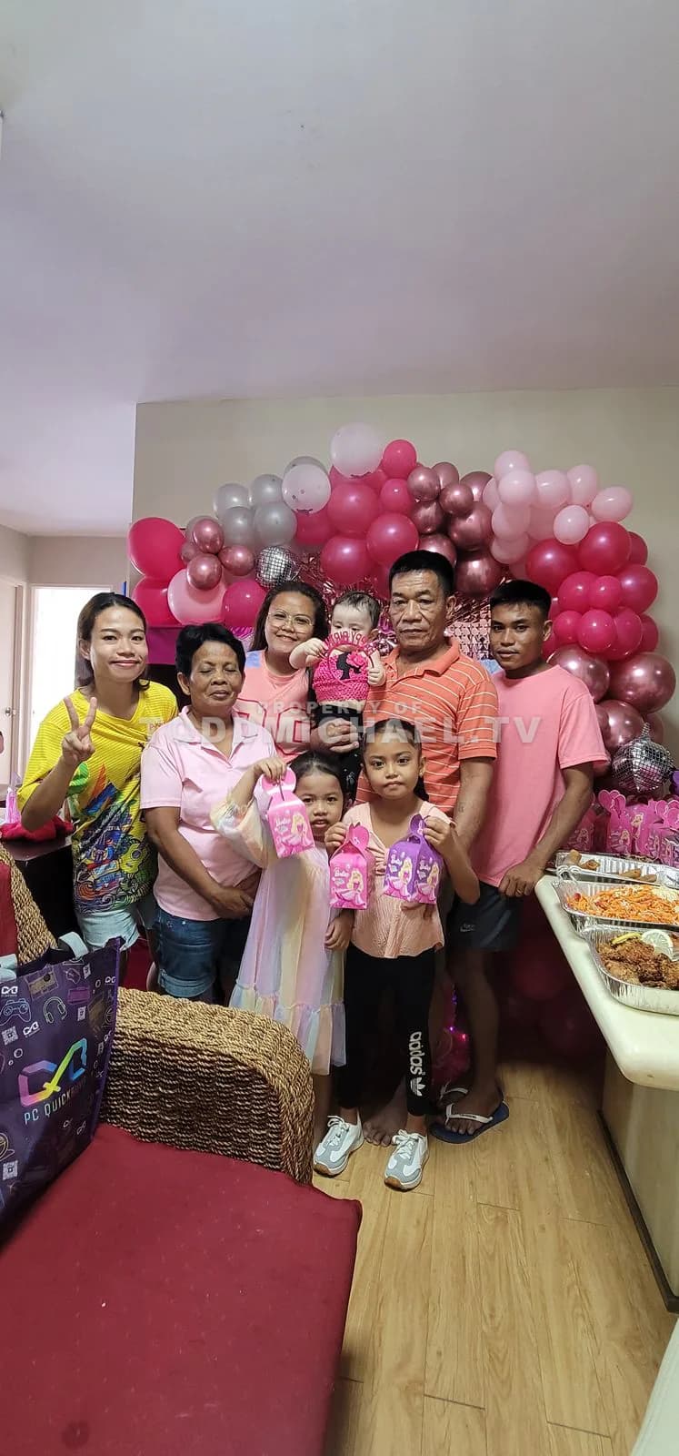 a family celebrating a birthday with balloons and cake