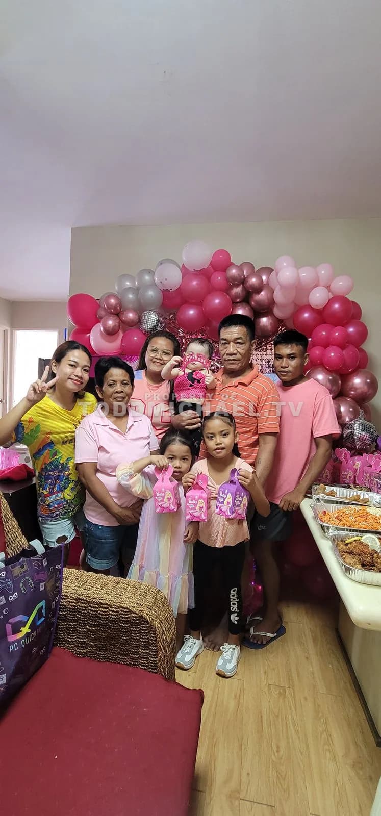 a family celebrating a birthday with balloons and cake