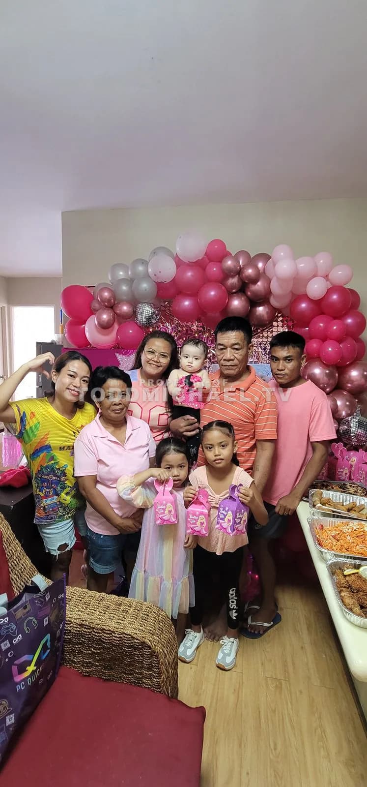 a family celebrating a birthday with balloons and cake